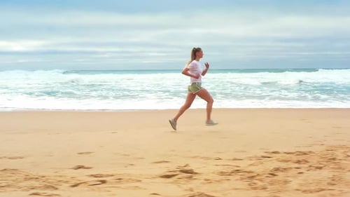 Drone Aerial Footage Women Jogging on Beach in Morning