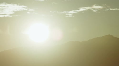Sun Setting Behind Mountains In Silhouette Time Lapse