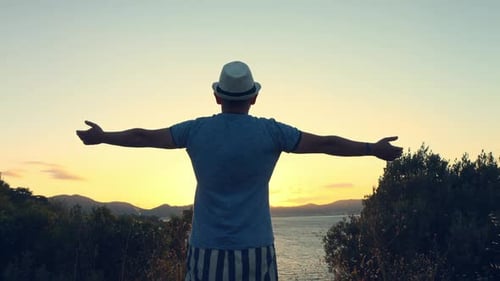 Silhouette of Man with Their Hands in the Sunset on the Sea