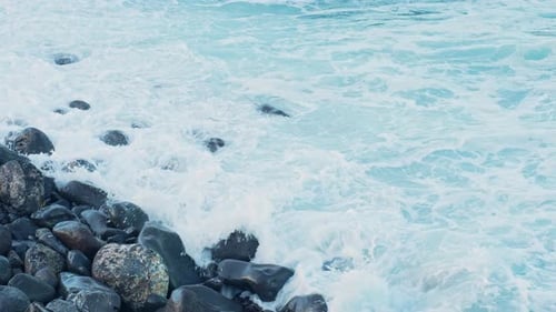 Crashing Waves on Rocky Shore Creating Sea Foam