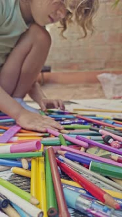 Young Girl Using Coloured Pens Drawing Picture in Vertical