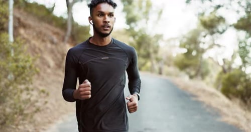 Man Jogging Down Paved Path in Nature