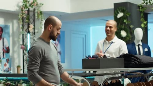 Mall Employee Assisting Customer to Choose From the New Collection of Clothes