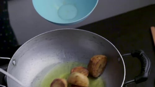 Potatoes Frying in Oil Being Removed and Placed in Bowl