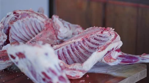 Freshly butchered lamb ribs on cutting board, artisanal meat preparation scene