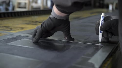 ouvrier industriel dessinant des lignes avec un marqueur blanc sur caoutchouc, gros plan, ralenti