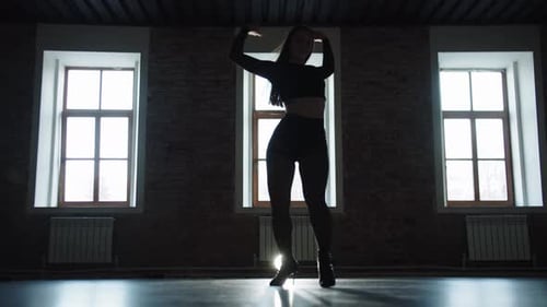 Sexy Woman Dancing in the Studio on the Background of White Windows