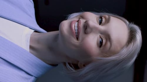 Smiling woman in blue suit jacket against black background