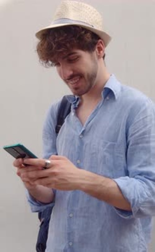 Vertical Vidoe Young Male Tourist Chatting on Mobile Phone While on Vacation