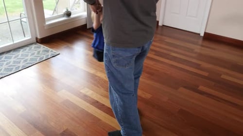 Un père fait tourner son fils par les bras à la maison