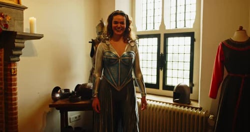 Wide view of an attractive woman dressed up in a warrior princess costume standing in an medieval ar