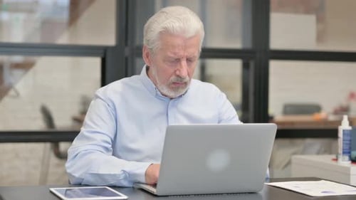 Coughing Old Businessman Using Laptop in Office