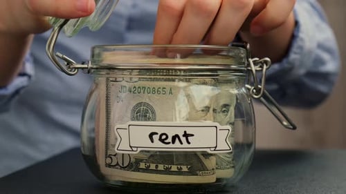 Female Hands Take Money From Glass Jar Full of American Currency Dollars Cash Banknote with Text