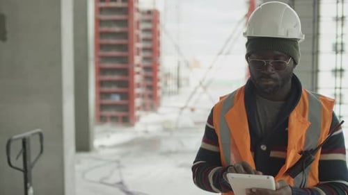 Porträt von Black Foreman mit digitalem Tablet auf der Baustelle
