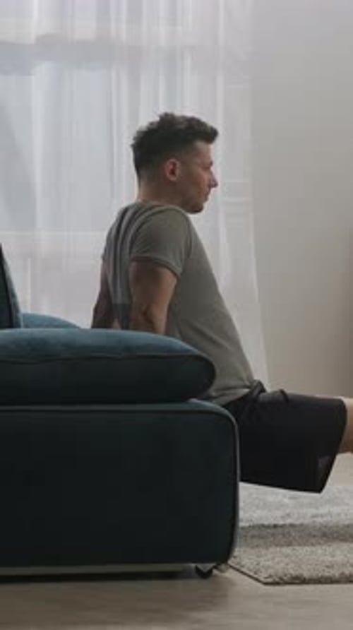 Man Doing Tricep Dips at Home on Couch