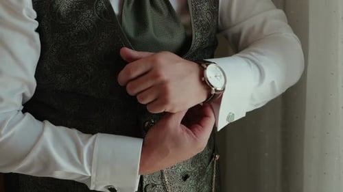 Man Buttons Ornate Vest, Preparing for Special Event