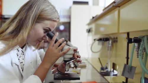 High School Student with Microscope in Laboratory