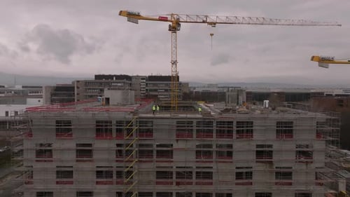 Luftaufnahme von Mitarbeitern in reflektierender Arbeitskleidung auf einer Baustelle, hoch gelb