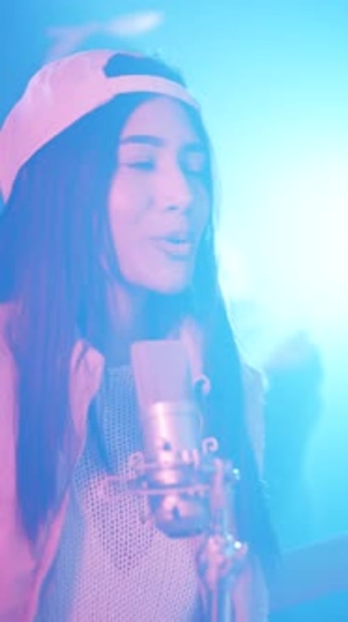 Young Female Rapper Singing Into a Studio Microphone Vertical