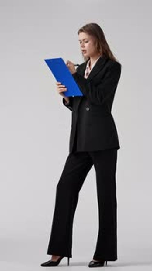 Professional Woman Writes on Blue Document in Studio