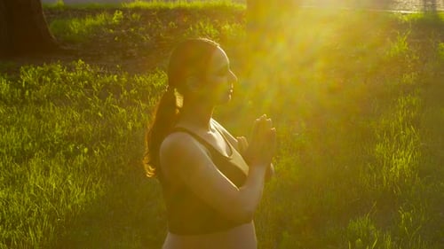 Woman Practices Yoga Outdoors at Sunset