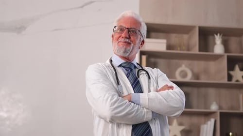 Mature Senior Male Doctor in Glasses Medical Uniform Smiling Looking at Camera in Hospital or Doctor