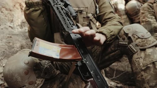 An Unidentified Military Man Holds a Weapon in His Hands