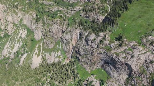 Waterfall Cascading Down Rocky Mountainside in Summer