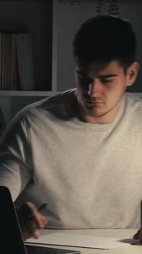 Estudiante masculino de preparación para el examen de estudio nocturno vertical