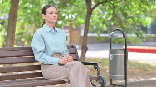 Woman Sits on Bench and Checks Watch