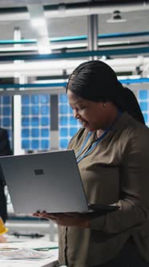 Vertical Video African American Woman Checking System Diagnostics in a Solar Panel Plant