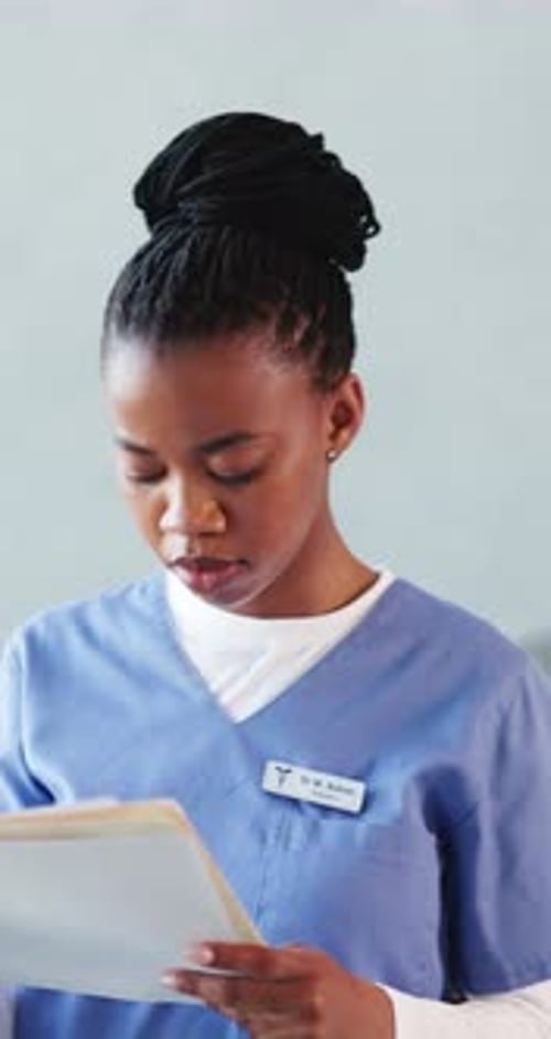Black woman, doctor and reading with folder at hospital for medical file