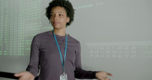 Black Young Adult FemaleEngineer Presenting in Office using Projection Screen