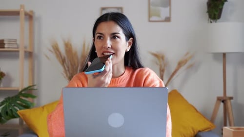 Woman Talking into Phone at Desk with Laptop
