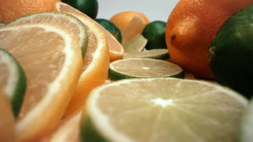 Lemon and lime tower macro close up with dropped lemon wedge push in probe 4k product food video fre