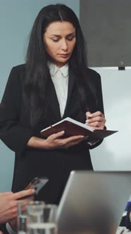 Vertical Screen Businesswoman Taking Notes During Meeting