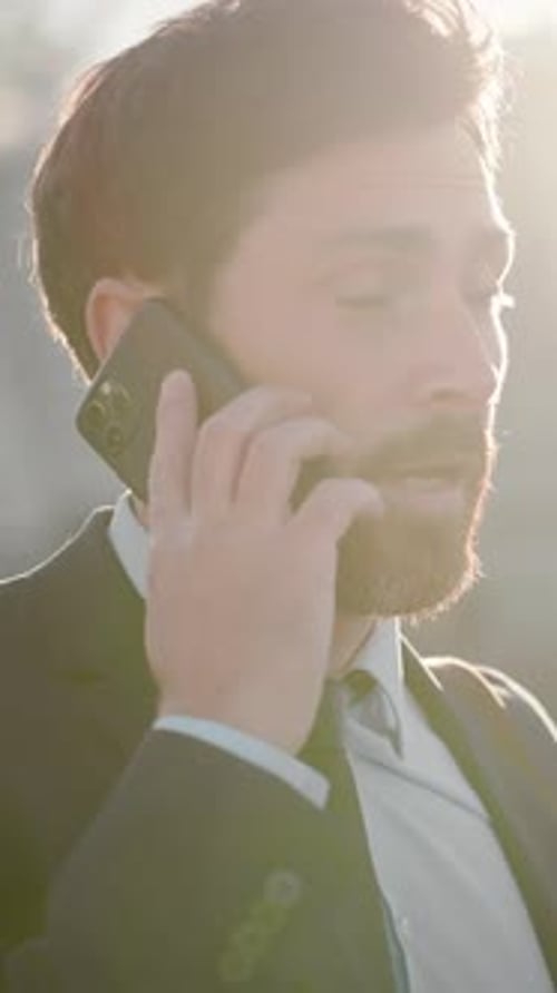 Businessman Talks to Client on Phone Walking Down Street