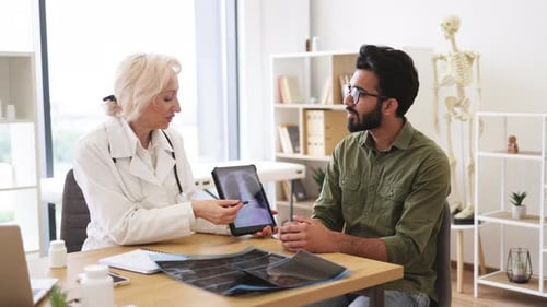 Doctor Consults Patient with X-Ray on Tablet