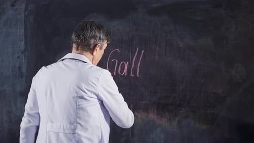 Male doctor writes Gallbladder on the blackboard.