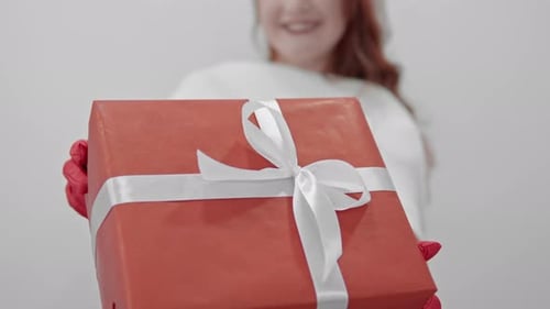 Woman in Santa Hat Gives a Holiday Gift