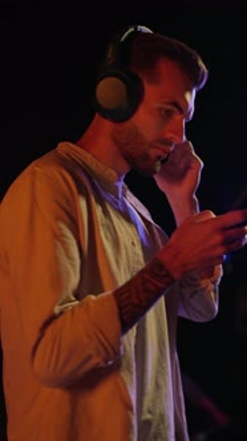 Young Adult Using Smartphone with Headphones at Night