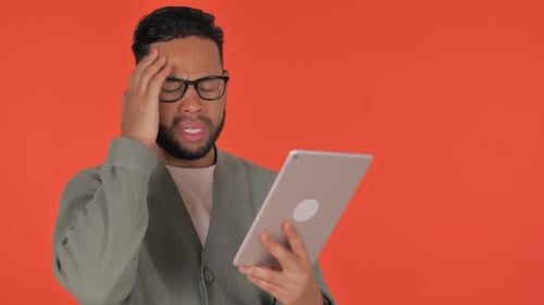 Man looks shocked while using a tablet device