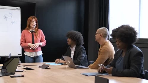 Woman Giving Presentation to Coworkers in Conference Room