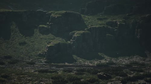 A Mountain Range with Rocks and Grass in the Foreground
