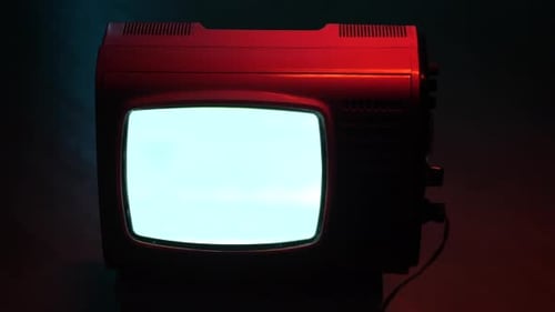 Altes rotes Fernsehgerät mit statischem Bildschirm im dunklen Raum