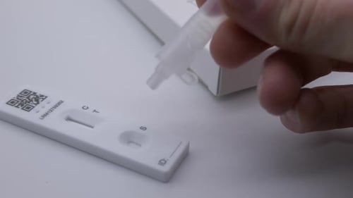 Hombre de cerca que usa en casa el kit de prueba de antígenos de flujo rápido Covid