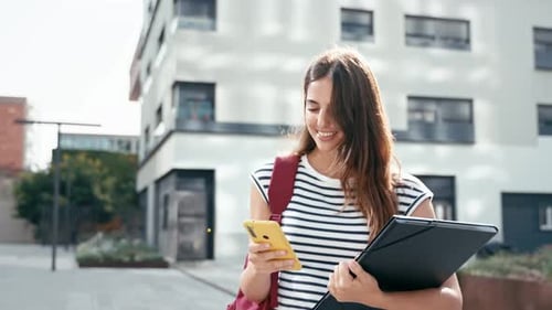 Young Hispanic Woman Walking While Using Cell Phone Happy University Student Girl Smiling in the