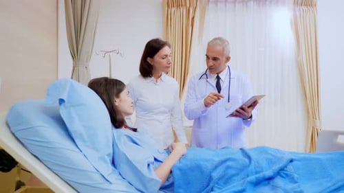 Caucasian senior mother look after her sick daughter in hospital ward.