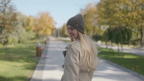 Smiling Woman Walks Along Tree Lined Path
