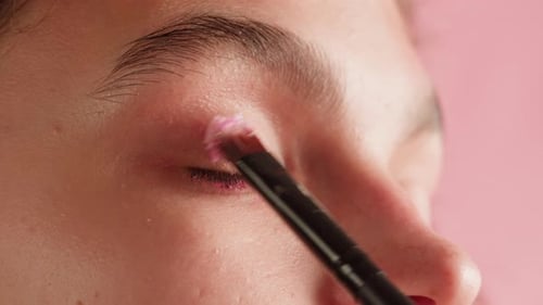 Lidschatten-Make-up auf das Oberlid Closeup Makeup Artist trägt einen hellen Lidschatten mit einem